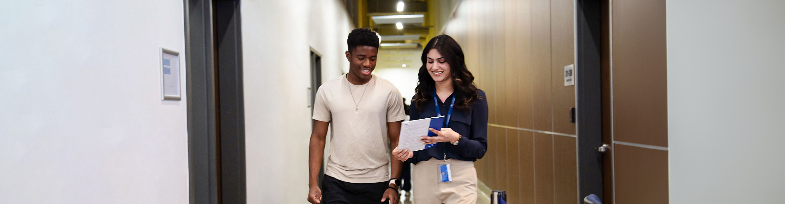 Alexander College staff walking with a student while helping them