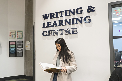 Student standing under the WLC sign