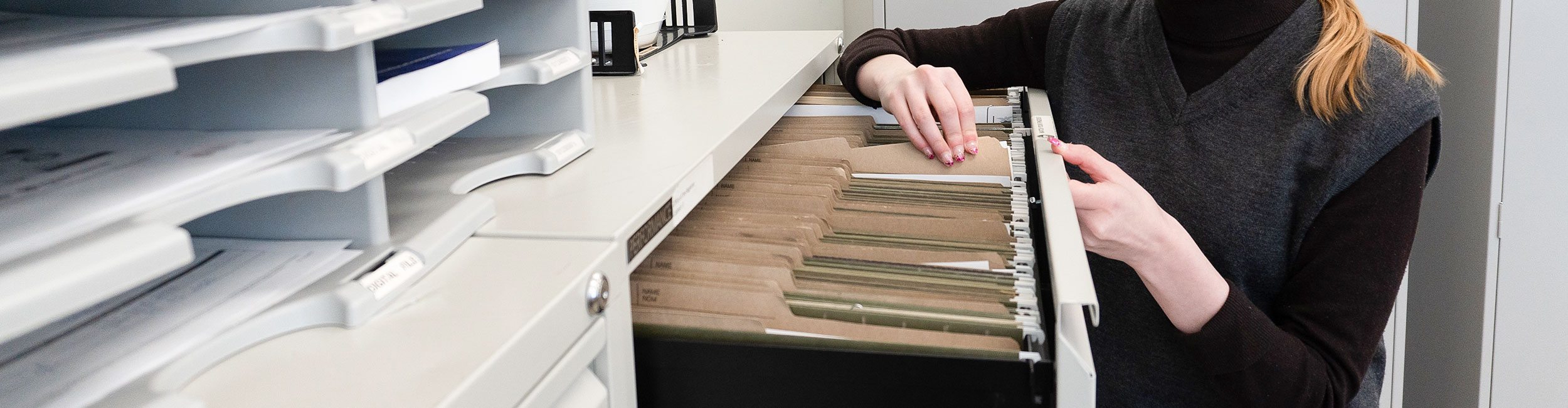 close up shot of staff going through a filing cabinet