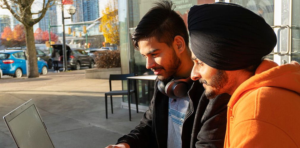two students looking at a laptop