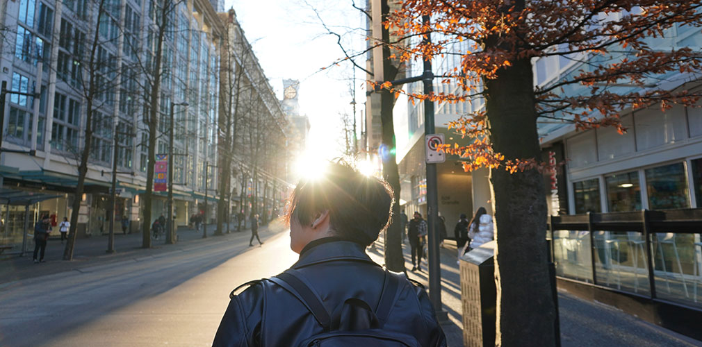 backlight student walking downtown