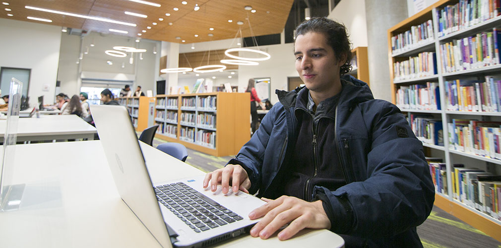 Fernando using a laptop in the library