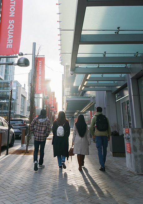 four students walking around Station Square