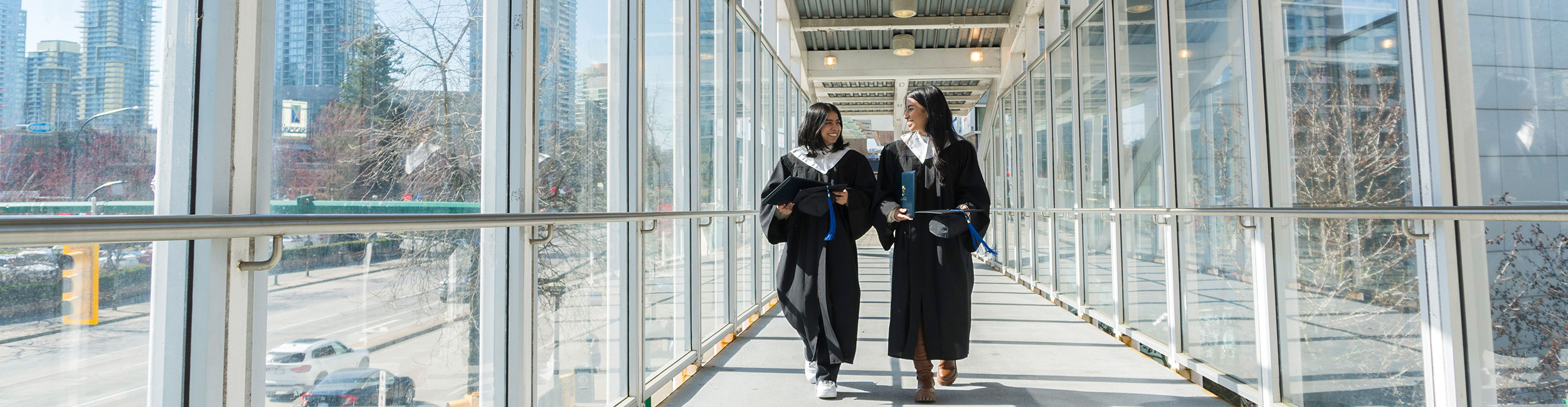 Two students in graduation regalia