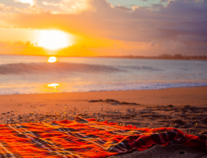 picnic blanket on the beach at sunset