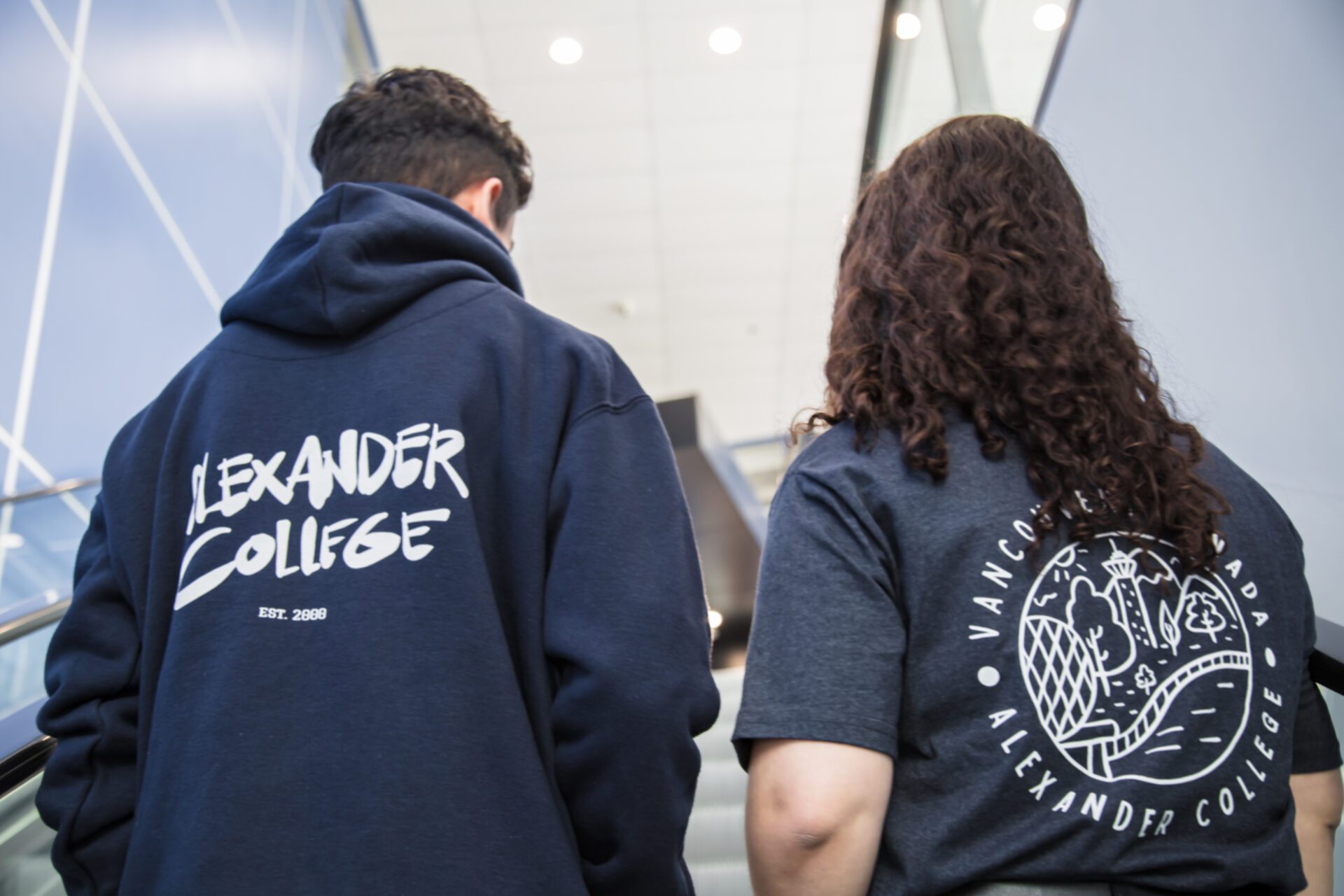 Backs of 2 students wearing school merch