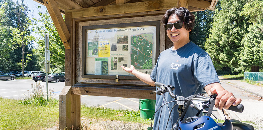 student posing in front of a sign at Central Park
