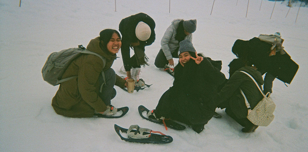 a group of students laughing in the snow