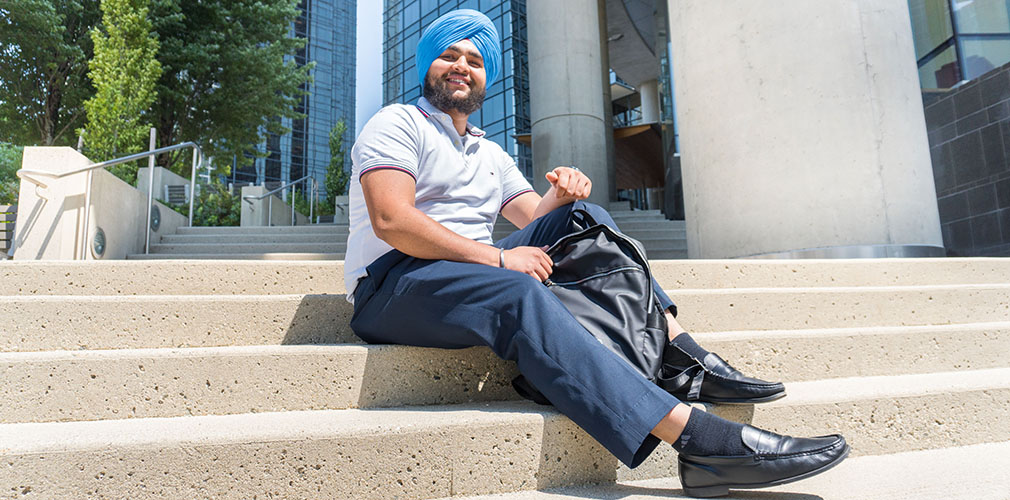 Rajveer sitting on the steps to Metrotown