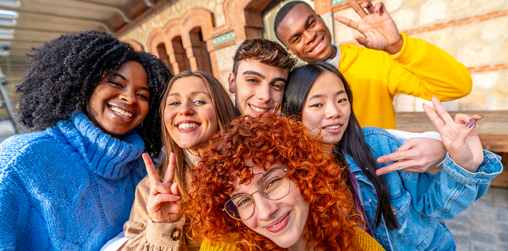 Students gesturing success while taking a selfie in the city