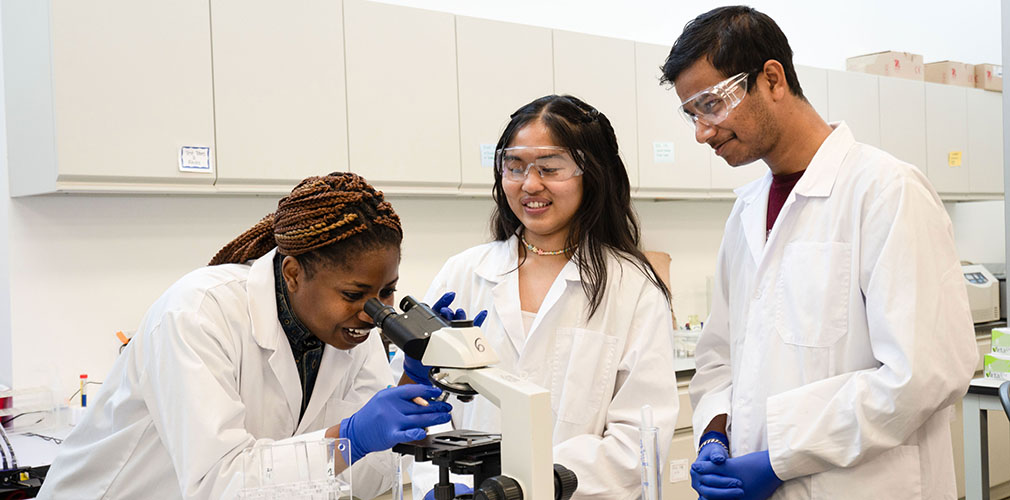 three students in a labratory