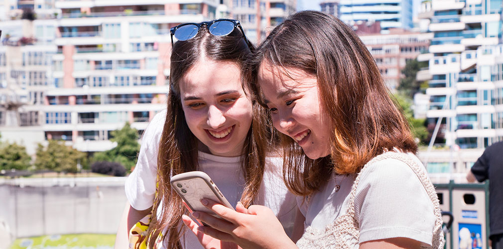 two students looking over a phone