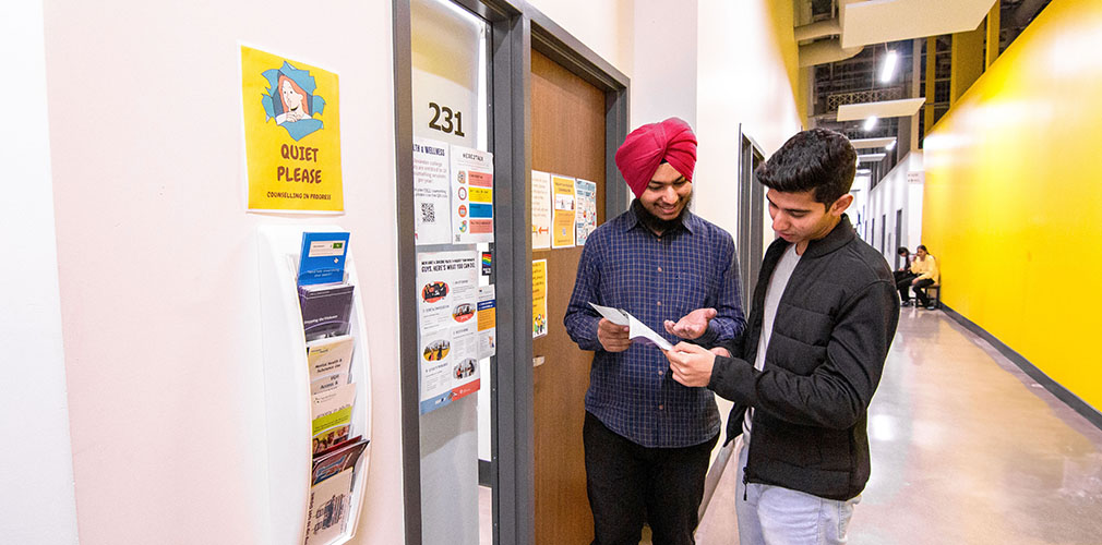 two students outside the Health and Wellness office