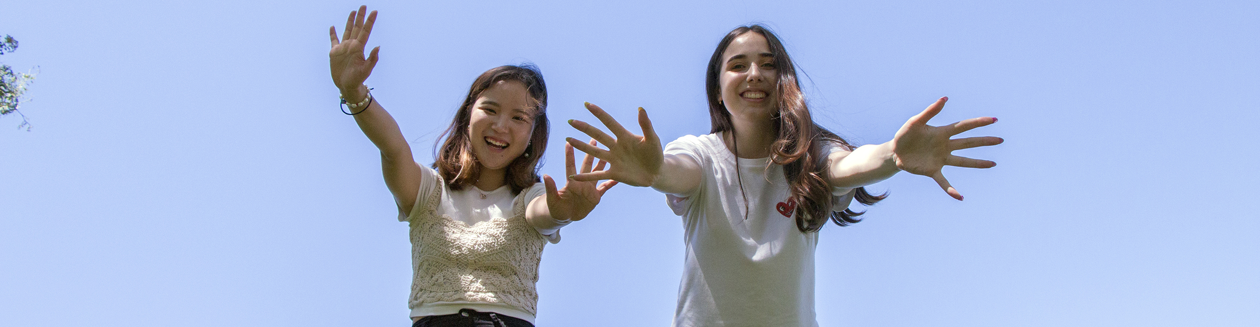 Two students posing for the camera outside