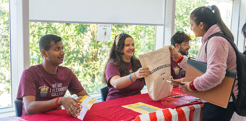 volunteer handing a student an NSO goody bag